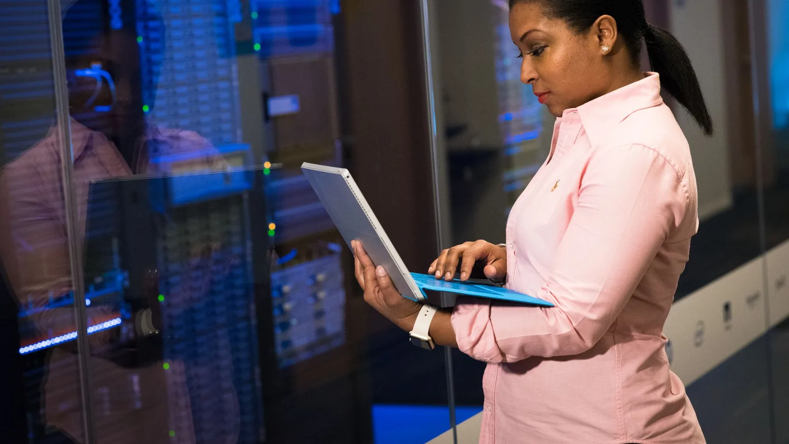 Software engineer monitoring systems from a server room