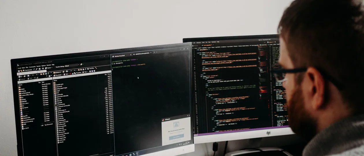 Developer working across a multi-screen web development workspace