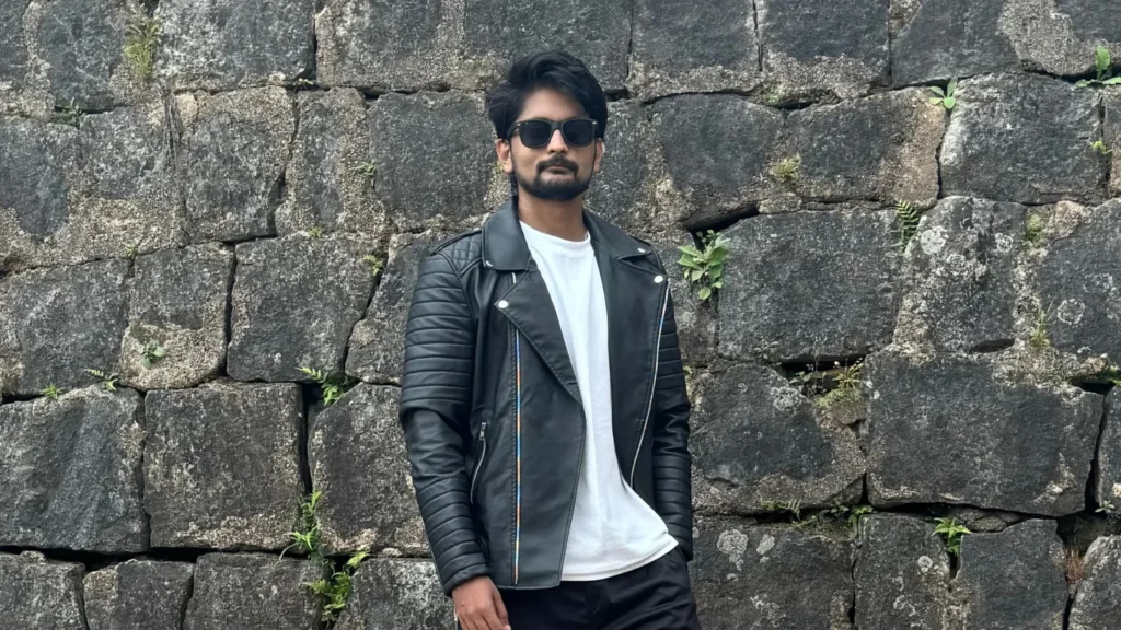 amar karthik standing with a black leather jacket