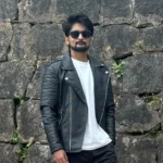 amar karthik standing with a black leather jacket